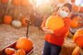 Cute Girl Choosing A Pumpkin At Pumpkin Patch Wearing Medical Face Mask Royalty Free Stock Photo