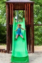 Cute girl chuting down slide at playground Royalty Free Stock Photo