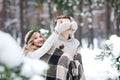 Cute girl covering boyfriend`s eyes by her knitted mittes. Winter wedding. Artwork. Royalty Free Stock Photo