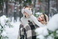 Cute girl covering boyfriend`s eyes by her knitted mittes. Winter wedding. Artwork. Royalty Free Stock Photo