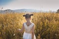 Cute girl dancing through a beautiful meadow with wheat and flowers in the mountains Royalty Free Stock Photo