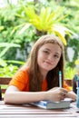 Cute girl doing her homework in the garden at home Royalty Free Stock Photo