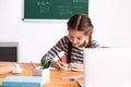 Cute girl doing homework in classroom Royalty Free Stock Photo