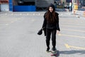 Nice girl with dreadlocks in a hood rides a skateboard