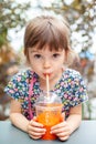 Cute girl drinking carrot juice Royalty Free Stock Photo