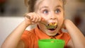 Cute girl eating cereal closeup, appetizing breakfast, morning corn flakes meal