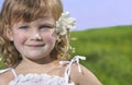 Cute girl with flower on blue sky and green grass Royalty Free Stock Photo