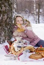 Cute girl in a folk headscarf with pancakes, samovar and traditional russian utensil with khokhloma painting.