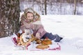 Cute girl in a folk headscarf with pancakes, samovar and traditional russian utensil with khokhloma painting.