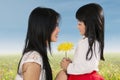 Cute girl giving flower to her mom Royalty Free Stock Photo
