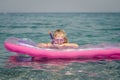 Cute girl with glasses for diving on inflatable pink airbed and sunbathing Royalty Free Stock Photo