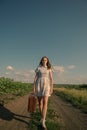 Cute girl goes on a dirt road in field Royalty Free Stock Photo