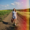 Cute girl goes on a dirt road in field Royalty Free Stock Photo