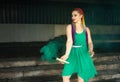 Cute girl in a green dress with African braids and colorful makeup posing with bright green smoke on the streets of a Royalty Free Stock Photo