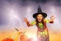 Girl scary in Halloween costume stand near pumpkin
