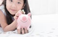 Cute girl hand put money to piggybank Royalty Free Stock Photo