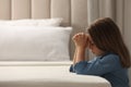 Cute little girl with hands clasped together saying bedtime prayer in bedroom. Space for text Royalty Free Stock Photo