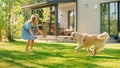 Cute Girl Has fun with Happy Golden Retriever Dog on the Backyard Lawn. She Pets, Play, Tackle it Royalty Free Stock Photo