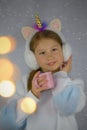 Cute girl has warm plush ear muffs with horn unicorn.