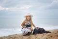 Cute girl in a hat hugging a dog on the beach Royalty Free Stock Photo