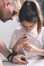 Cute girl and her father are assembling furniture with a screewdriver. Housework. Front view. Vertical shot. Close-up