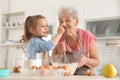Cute girl and her grandmother cooking