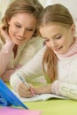 Cute girl with her mother doing homework Royalty Free Stock Photo