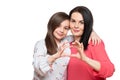 Cute girl and her mother making together heart shape hand gesture. Family love, care and support. Mom and daughter.