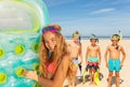 Cute girl hold matrass stand on beach with friends Royalty Free Stock Photo