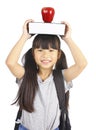 Cute girl holding book and apple on the head Royalty Free Stock Photo