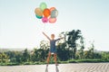 Cute girl holding colorful balloons in the city park, playing Royalty Free Stock Photo