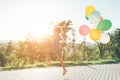 Cute girl holding colorful balloons in the city park, playing, r Royalty Free Stock Photo