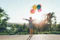 Cute girl holding colorful balloons in the city park spreding ar Royalty Free Stock Photo