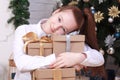 Cute girl holding gift boxes sitting next to a Christmas tree Royalty Free Stock Photo