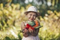 Cute girl holding vegetables from the garden, fresh rural products in hands