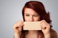 Cute girl holding white card at front of her lips with copy space Royalty Free Stock Photo