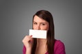 Cute girl holding white card at front of her lips with copy space Royalty Free Stock Photo