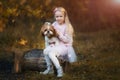 A cute girl hugs a Shih Tzu dog in the autumn forest. A girl walks with a dog in an autumn park Royalty Free Stock Photo