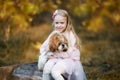 A cute girl hugs a Shih Tzu dog in the autumn forest. A girl walks with a dog in an autumn park Royalty Free Stock Photo