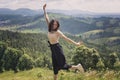 Cute girl is jumping against the backdrop of mountains and fores Royalty Free Stock Photo