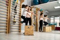 Cute girl jumping on wooden box in gym class