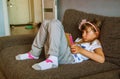 Cute girl kid using iPad digital computer tablet on bed for education or playing game. Royalty Free Stock Photo