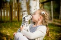 Cute girl kissing her puppy, doggy on the wood fence background.Happy girl with a dog licking her face.real friends Royalty Free Stock Photo