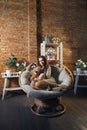 Cute girl in knee socks and sweater with Teddy bear in her hands sitting in armchair in fancy room Royalty Free Stock Photo