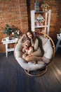 Cute girl in knee socks and sweater with Teddy bear in her hands sitting in armchair in fancy room Royalty Free Stock Photo