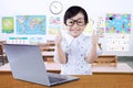 Cute girl with laptop shows thumbs up in class Royalty Free Stock Photo