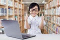Cute girl with laptop shows thumbs up Royalty Free Stock Photo