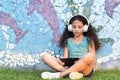 Young creative teenager girl sitting in the city park with laptop. Casual blogger child. Royalty Free Stock Photo
