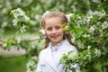 Cute girl listening to music in an apple blossom tree. adorable blonde enjoying music in headphones outdoors in a park. Children`