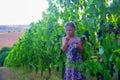 Cute girl little six years old girl tries a fresh red grape directly from the plant in a red vineyard. Concept of Royalty Free Stock Photo